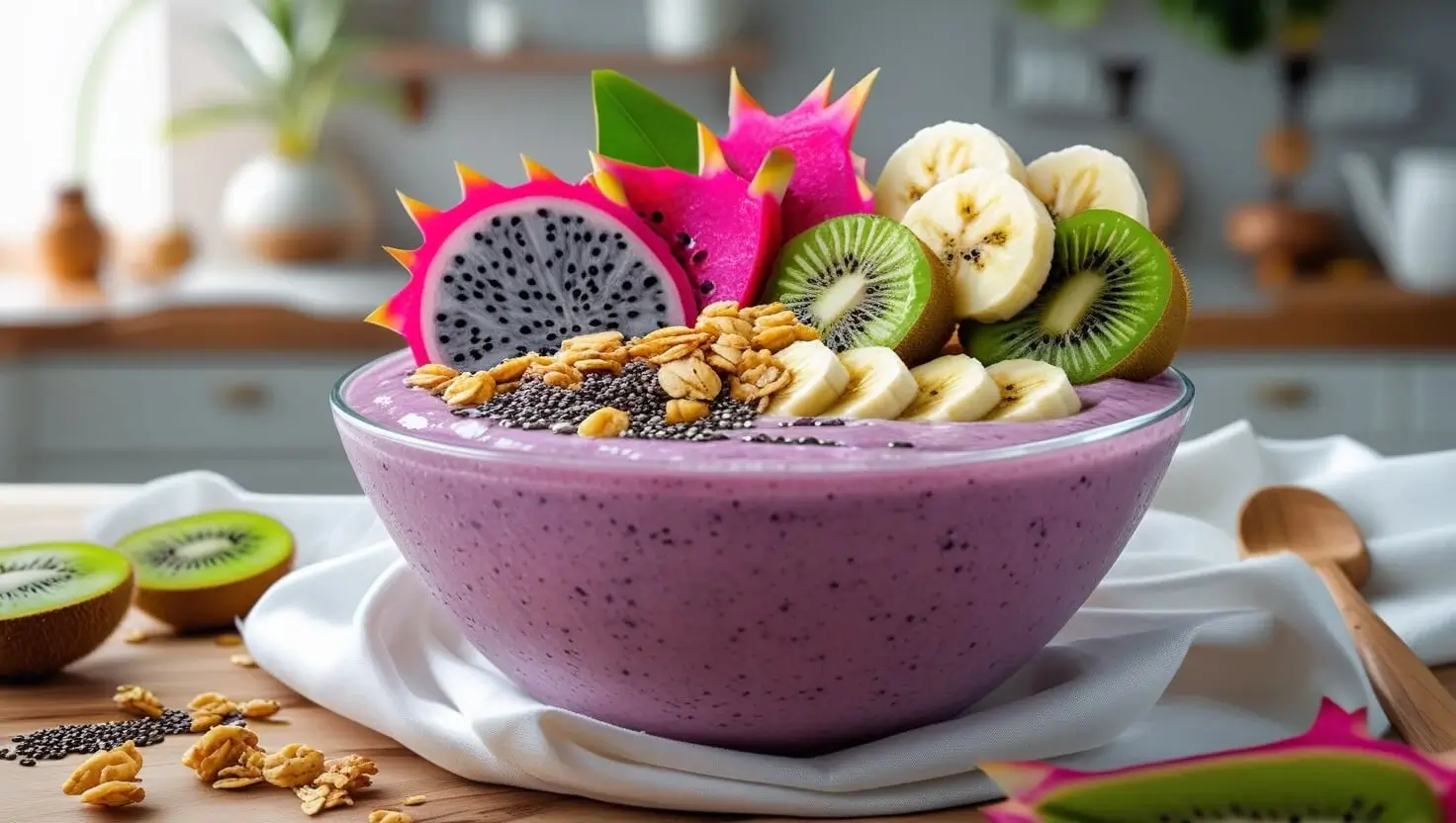Colorful dragon fruit bowl topped with granola, berries, and coconut flakes.